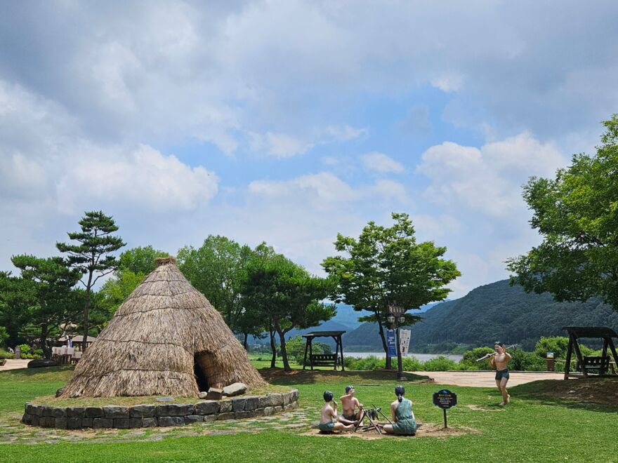 Life-size reconstruction of a prehistoric dwelling with life-size figurines in the museum park