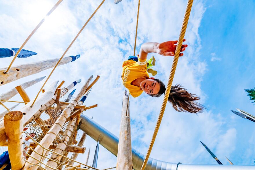 A young visitor playing upside down at the stone age playground