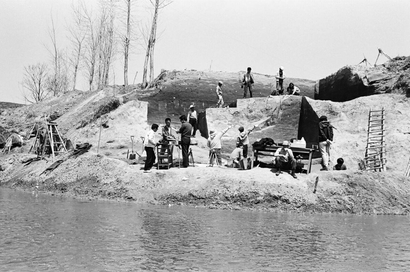 Black-and-white image of an excavation at a river