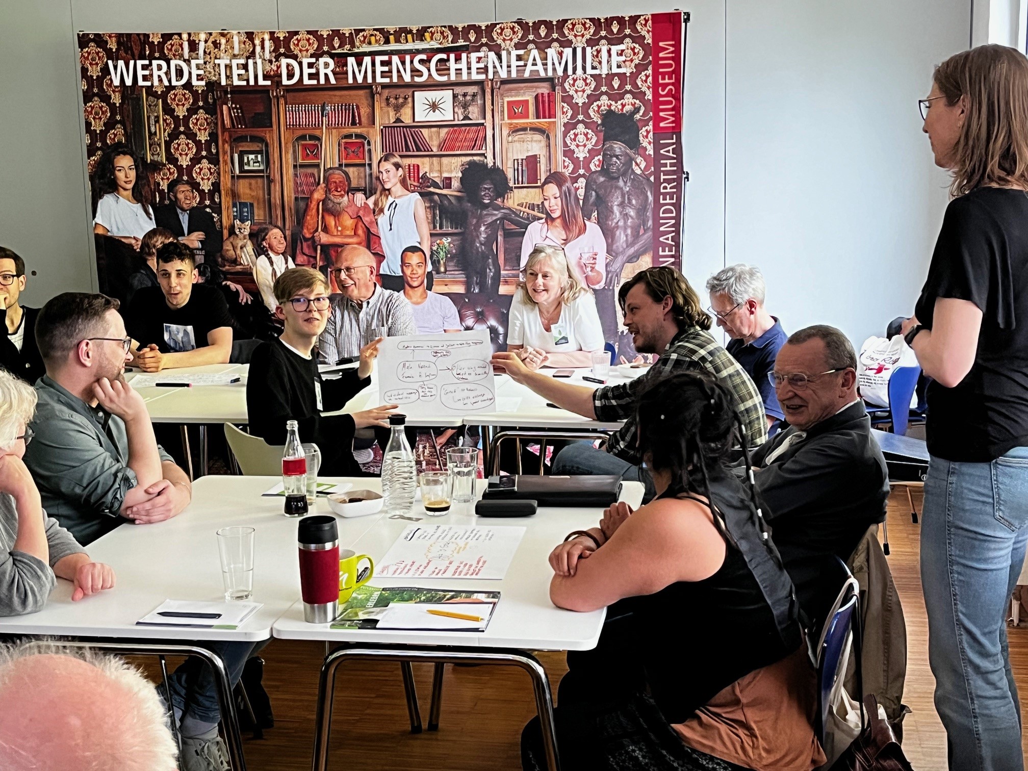 People around a table, discussing