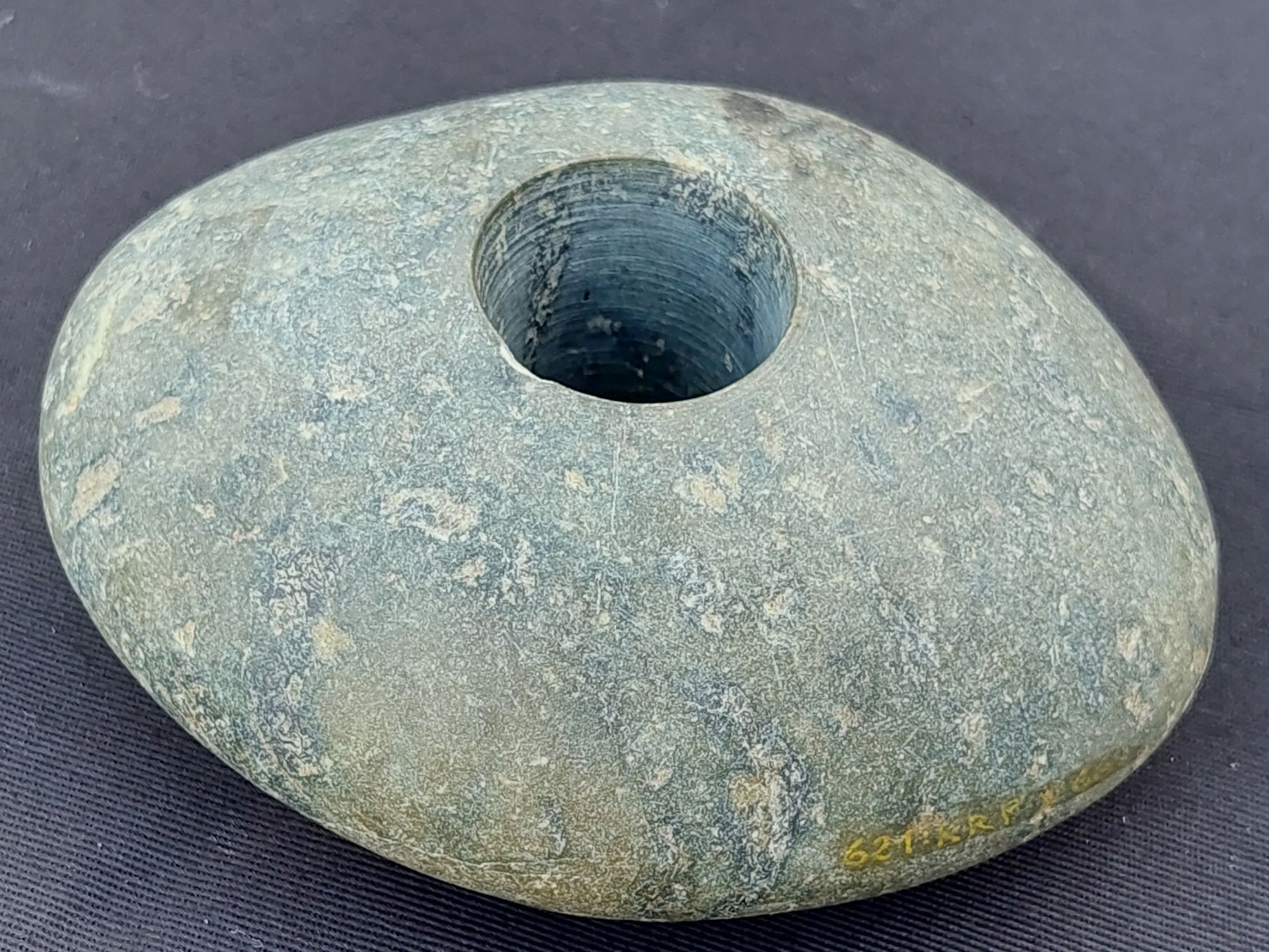 Polished grey stone with a round hole in the middle