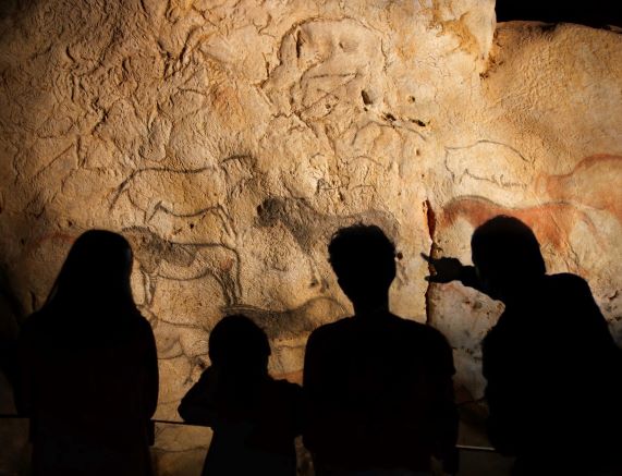 Vistors admiring a rock art panel at the replica of the Ekain Cave, Ekainberri