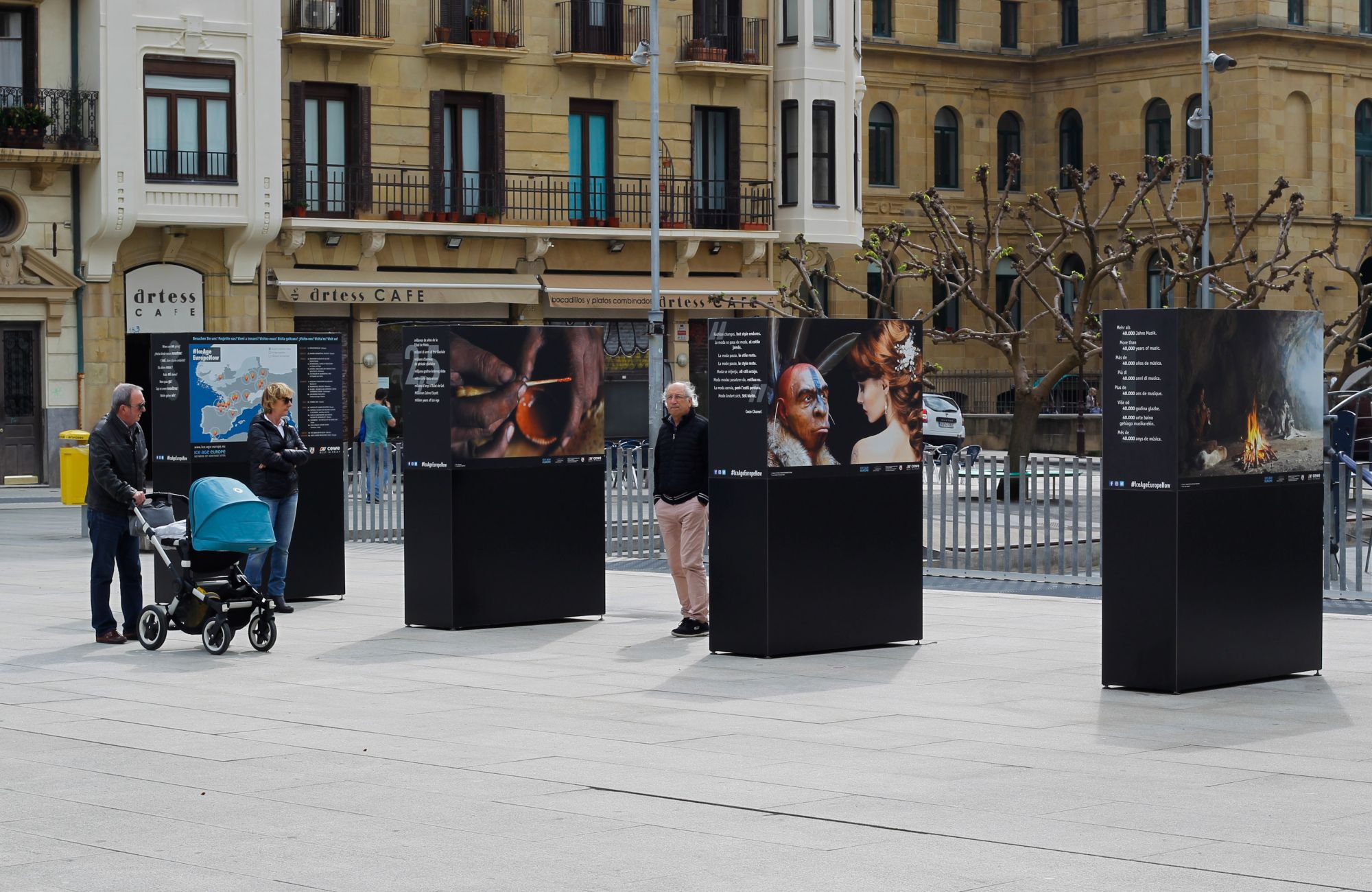 Large photo panels outside in an urban setting, with some visitors