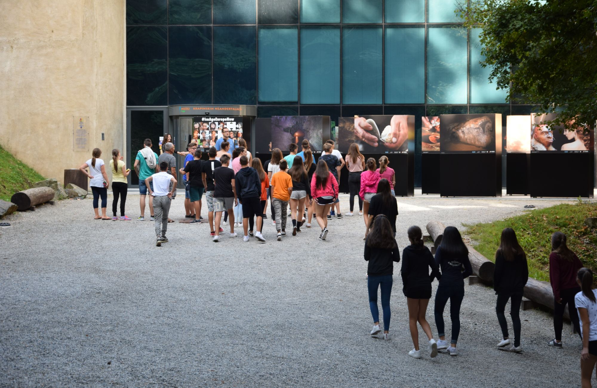 Large photo panels in from a museum with a group of students walking toward it